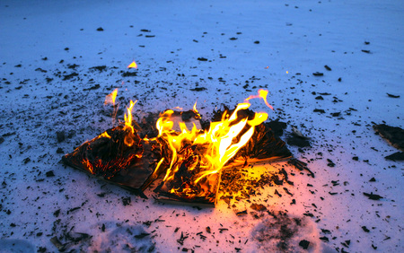 burning book in the snow. pages with the text in the open book burn with a bright flame.の写真素材