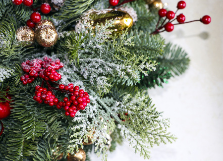 Christmas composition of pine branches, golden Christmas balls, red berries and artificial snow.の写真素材