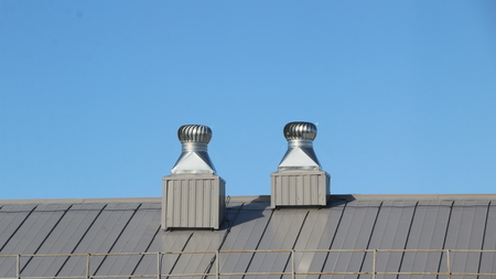 shiny metal air ventilation on the roof rotates to clean the air in the building and regulate the temperature.の写真素材