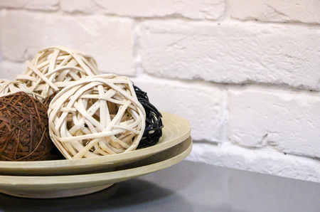 light and dark rattan balls on a wooden plate for decoration