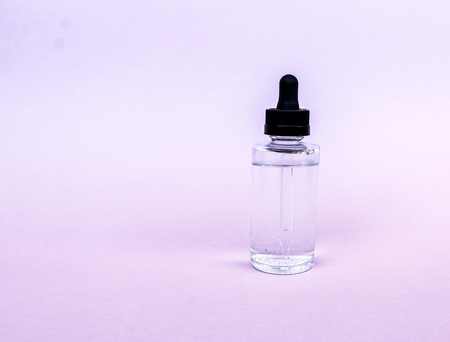 A glass bottle with a pipette with oil, serum  on an empty background. Concept: Organic bio cosmetics, herbal oils, serum collagen, skin careの写真素材