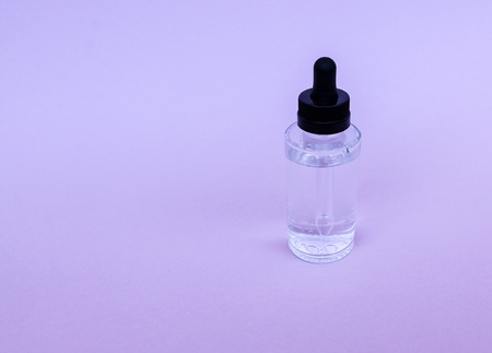 A glass bottle with a pipette with oil, serum  on an empty background. Concept: Organic bio cosmetics, herbal oils, serum collagen, skin careの写真素材