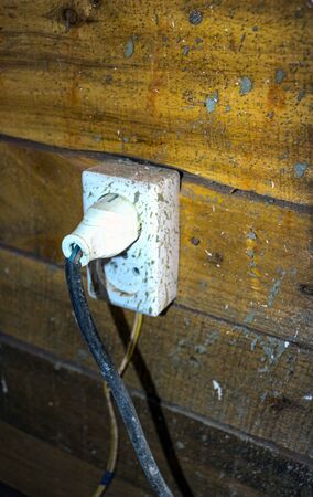 electrical outlets and switches made of white plastic on the wall in the room of an apartment or...