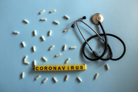 pills, stethoscope, thermometer, inhalation mask on a blue background with children`s yellow...