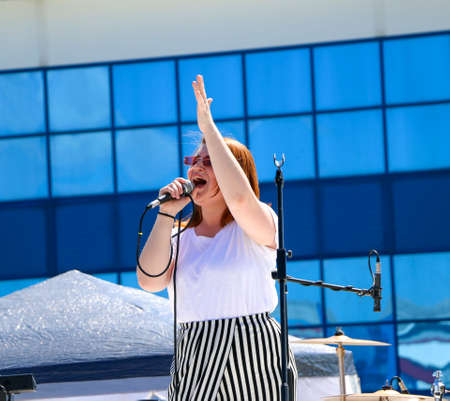 YOSHKAR-OLA, RUSSIA, JUNE 02, 2019: Auto and Motorcycle Exhibition - Festival - YO SUMMIT 2019 -  singer emotionally performs on stage, sings a cheerful, fiery song into the microphone.のeditorial素材