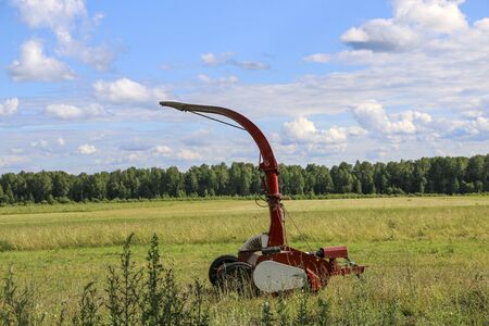 silage and forage harvesting equipment is standing on the edge of the field, waiting for work. A harvester near the field, before haymaking, and harvesting forage crops.の写真素材