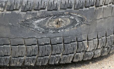 rubbed wheel of a lorry. worn wheel with a hole in the tire, worn rubber tread to the cordの写真素材