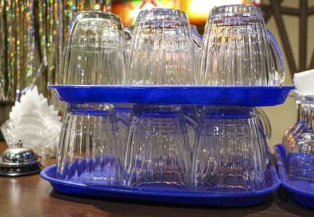 clean, washed, glass transparent mugs for beer and wine glasses for wine, stand in groups on plastic...