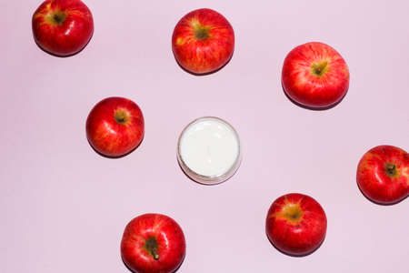 cosmetic composition with red ripe juicy apples, and an open jar with a white gentle moisturizing...