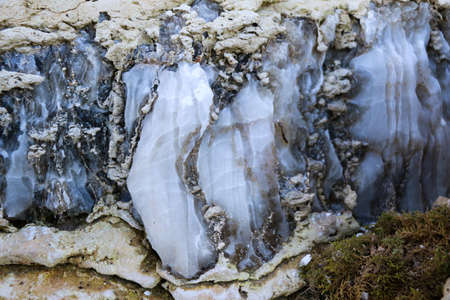 Diverse colored quartz rock in cut of earth. Deposits of gray, white, orange quartz. Untreated...