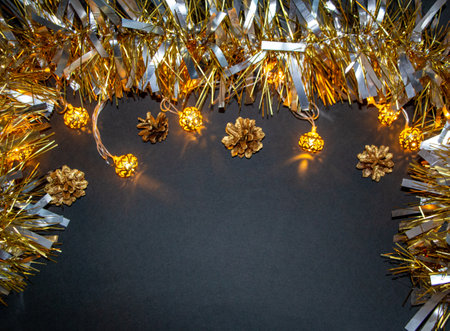 Christmas composition of New Year's balls, gilded cones, a luminous garland and golden fluffy tinsel.の写真素材