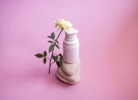 a white plastic jar with a dispenser and a gentle caring organic hand and body cream, on smooth...
