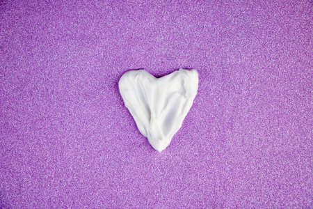 Drawing painted on textured strokes of white cream for skin care and moisturizing, on a shiny pink background.の写真素材