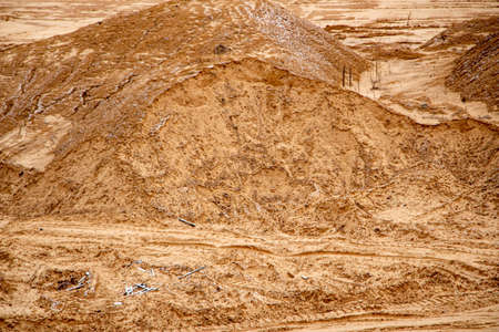 Textural sand, with a relief surface, multi-colored layers and different in size of granules, in an outdoor sand career, after mining ore and sand for construction.の写真素材