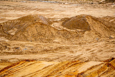 Textural sand, with a relief surface, multi-colored layers and different in size of granules, in an outdoor sand career, after mining ore and sand for construction.の写真素材