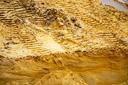 Textural sand, with a relief surface, multi-colored layers and different in size of granules, in an outdoor sand career, after mining ore and sand for construction.の写真素材