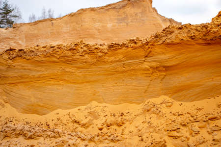Textural sand, with a relief surface, multi-colored layers and different in size of granules, in an outdoor sand career, after mining ore and sand for construction.の写真素材