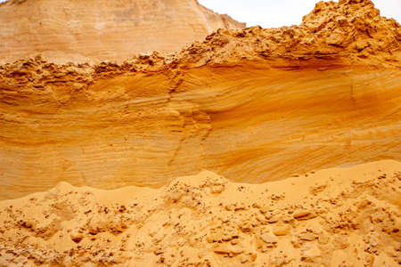 Textural sand, with a relief surface, multi-colored layers and different in size of granules, in an...
