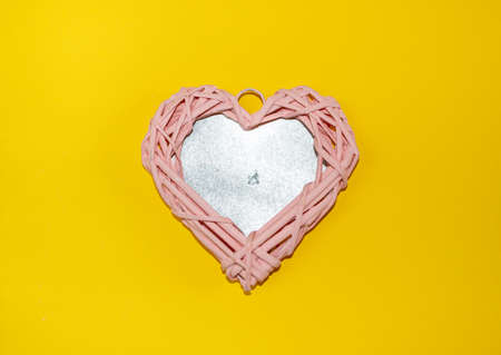 Beautiful pink wicker heart from natural vine branches, with festive accessories, glass toys and...