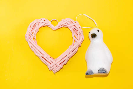 Beautiful pink wicker heart from natural vine branches, with festive accessories, glass toys and...