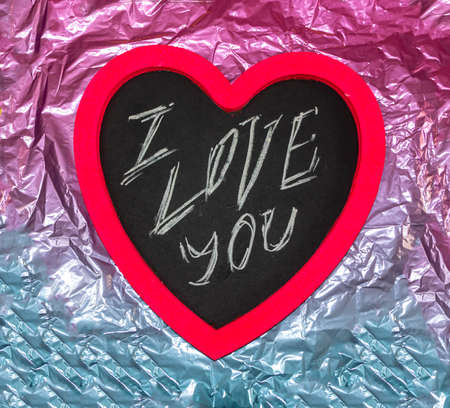 Wooden board for the inscriptions chalk in the shape of a pink heart with various festive...