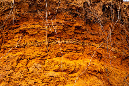 Textural sand, with a relief surface, multi-colored layers and different in size of granules, in an outdoor sand career, after mining ore and sand for construction.の写真素材