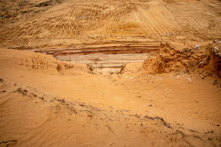 Textural sand, with a relief surface, multi-colored layers and different in size of granules, in an outdoor sand career, after mining ore and sand for construction.の写真素材