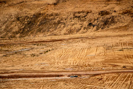 Textural sand, with a relief surface, multi-colored layers and different in size of granules, in an outdoor sand career, after mining ore and sand for construction.の写真素材