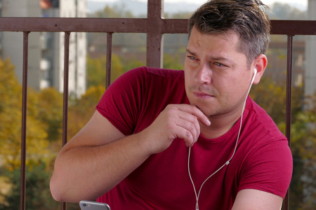 Man listening to music on a balconyの写真素材