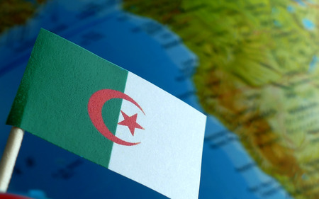 Algerian flag with a globe map as a background macroの写真素材
