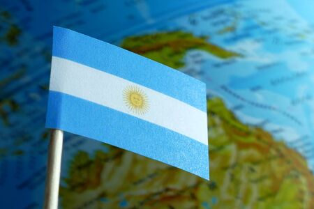 Argentine flag with a globe map as a background macroの写真素材