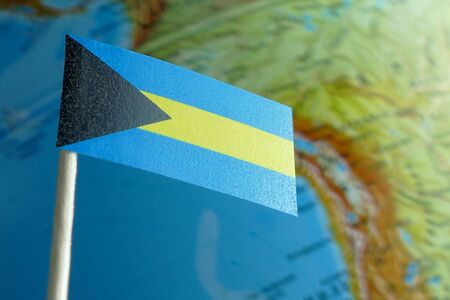 Bahamas flag with a globe map as a background macroの写真素材