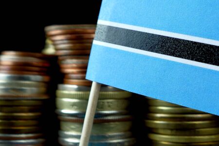 Botswana flag waving with stack of money coins macroの写真素材