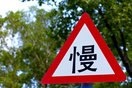 Slow traffic sign in Chinese word  sign close upの写真素材