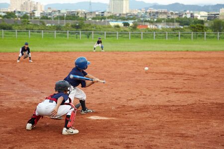 New Taipei City, Taiwan, May 18th 2011: Children  playing baseball in fieldのeditorial素材