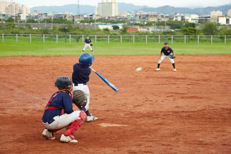 New Taipei City, Taiwan, May 18th 2011: Children  playing baseball in fieldのeditorial素材