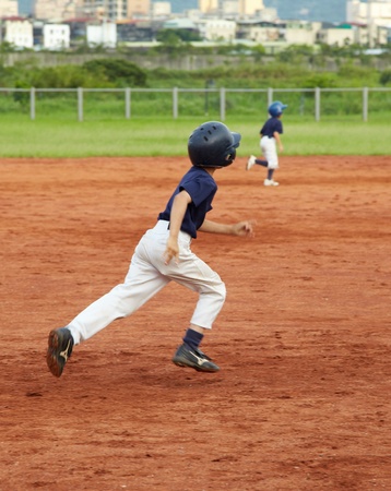 New Taipei City, Taiwan, May 18th 2011: Children  playing baseball in fieldのeditorial素材