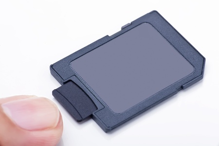 black front side micro SD memory card inserts into SD card adapter with one finger