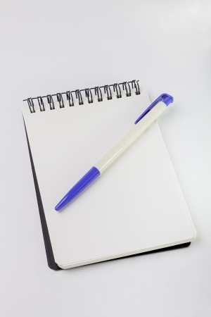 empty white note, pen and blue clip with white backgroundの写真素材