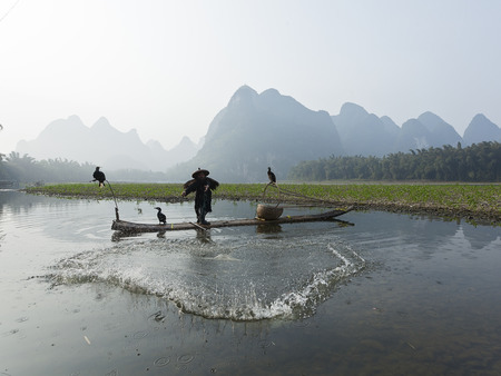 Cormorant, fish man and Li River scenery sight with fog in spring, Guilin, Chinaのeditorial素材