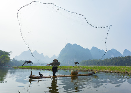 Cormorant, fish man and Li River scenery sight with fog in spring, Guilin, Chinaのeditorial素材