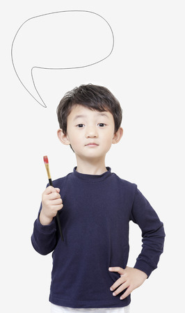 one asian boy child holds painting brush with white backgroundの写真素材