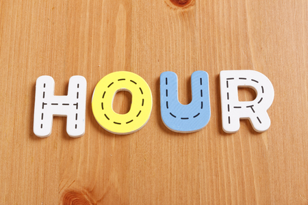 HOUR, spell by woody puzzle letters with woody backgroundの写真素材