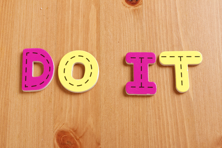 DO IT, spell by woody puzzle letters with woody backgroundの写真素材