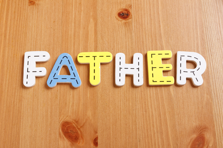 FATHER, spell by woody puzzle letters with woody backgroundの写真素材