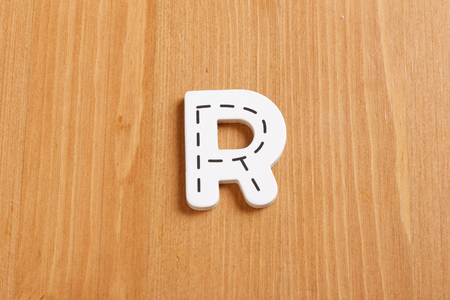 R, spell by woody puzzle letters with woody backgroundの写真素材