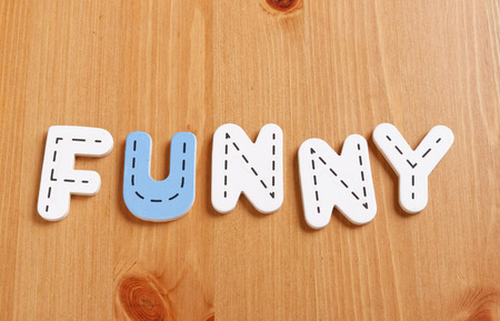 FUNNY, spell by woody puzzle letters with woody backgroundの写真素材