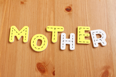MOTHER, spell by woody puzzle letters with woody backgroundの写真素材