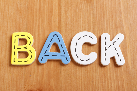 BACK, spell by woody puzzle letters with woody backgroundの写真素材