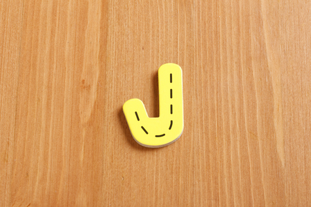 J, spell by woody puzzle letters with woody backgroundの写真素材